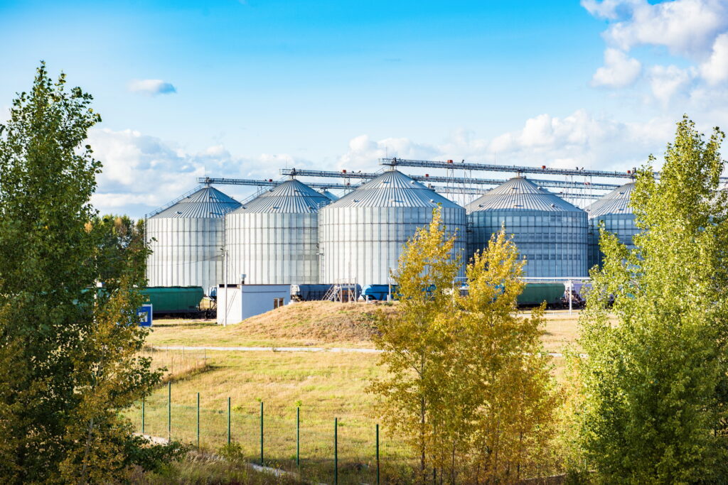 Silver silos on agro manufacturing plant for processing drying cleaning