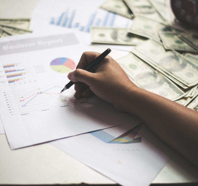 Businessman with documents chart on workplace with dollar usd money on background.